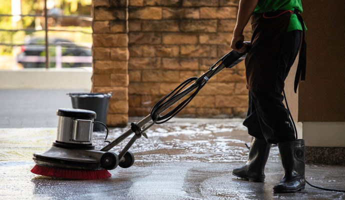 A cleaner cleans the carpet with machine