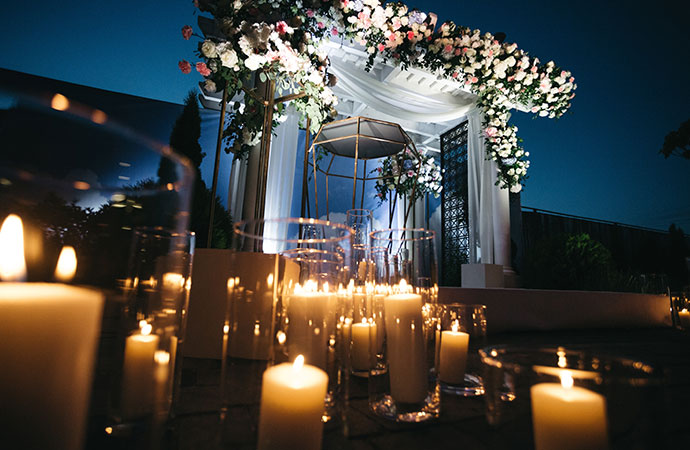 special event flower garland hangs before blue wall in the garden